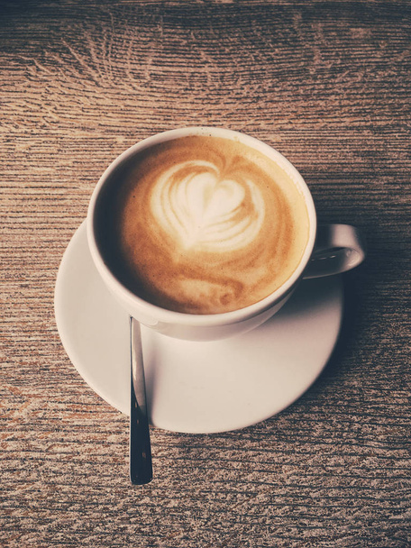 Tazza di cappuccino caldo in una caffetteria, caffè su un tavolo di legno i
 - Foto, immagini