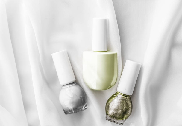 Nail polish bottles on silk background, french manicure products - Foto, afbeelding