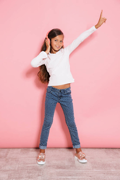 Positive young girl child dancing isolated listening music - Valokuva, kuva