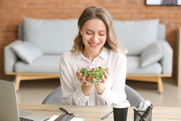 Mujer con ensalada de verduras saludables en la oficina
 - Foto, imagen