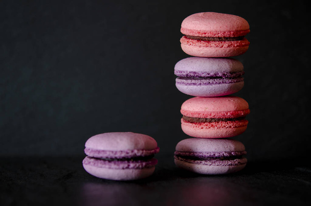 Macarrones sobre fondo oscuro, coloridas galletas francesas macarrones. Macarrones
 - Foto, Imagen