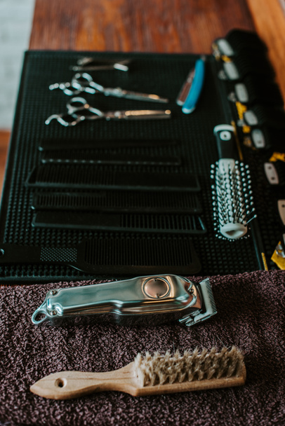 selective focus of hair brushes near trimmer in barbershop  - Fotoğraf, Görsel