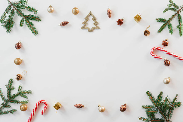 Weihnachtsbordüre flach mit Fichtenzweigen, Goldelementen, Süßigkeiten. Weihnachtsmuster auf weißem Hintergrund. Weihnachtskarte. Kopierraum - Foto, Bild
