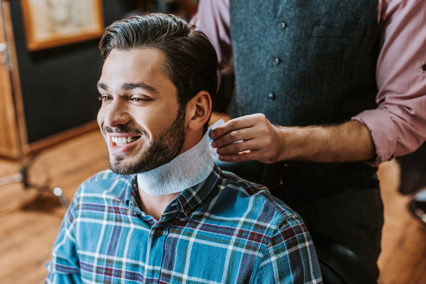 barber fixing collar around neck of happy man  - Zdjęcie, obraz