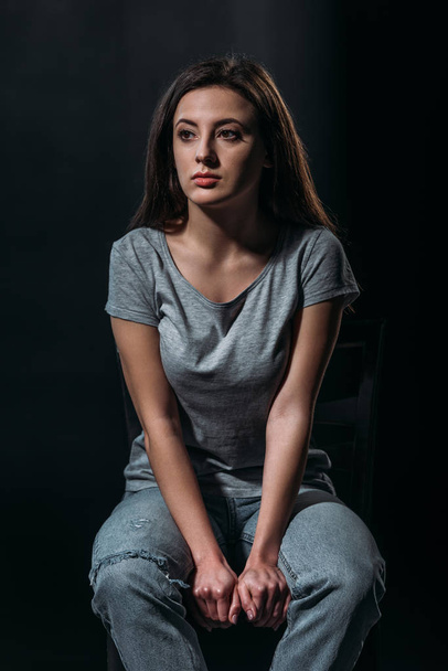 depressed girl looking away while thinking about suicide isolated on black - Фото, изображение