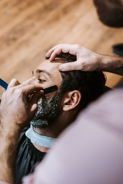 foyer sélectif de barbier rasoir homme avec crème à raser sur le visage
  - Photo, image