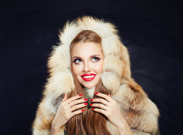 Beautiful Young winter woman in fur hood. Girl with red nails - Fotó, kép