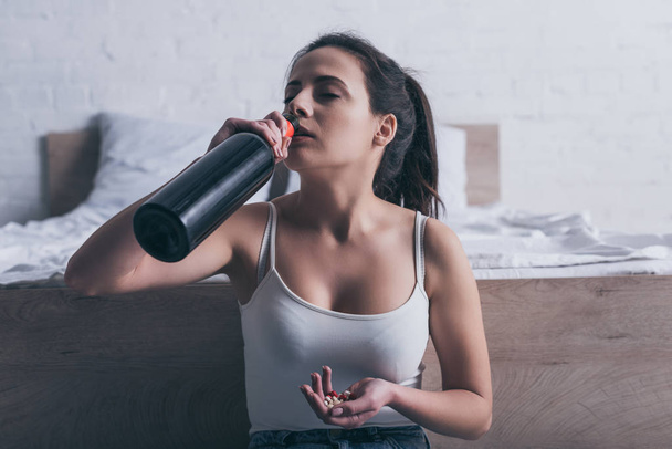 depressed young woman drinking alcohol and going to commit suicide by overdosing medicines - Zdjęcie, obraz