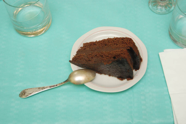Το κομμάτι κέικ σοκολάτας είναι στο σερβιρισμένο τραπέζι.. - Φωτογραφία, εικόνα