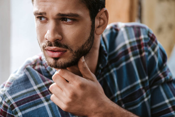handsome bearded man touching face in barbershop  - 写真・画像