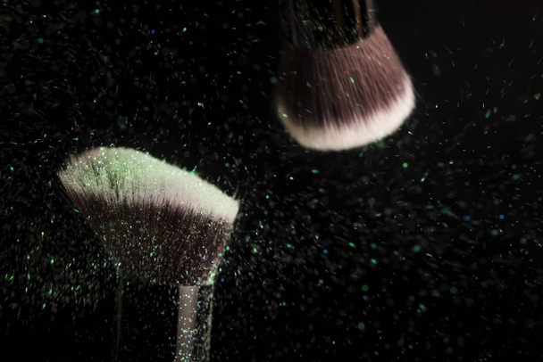 Cosmetics brush and colorful makeup powder - Foto, afbeelding