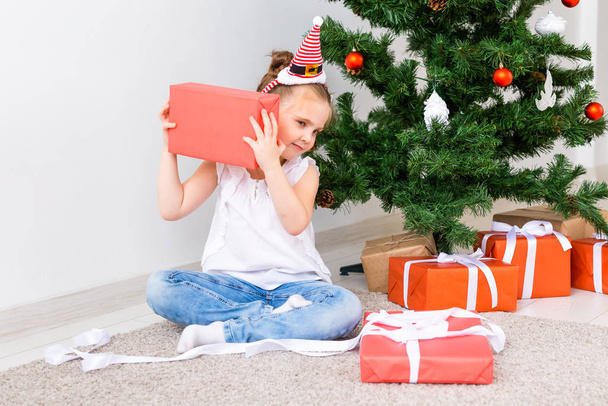 Çocuk Noel hediyelerini açıyor. Noel ağacının altında hediye kutularıyla çocuk. - Fotoğraf, Görsel