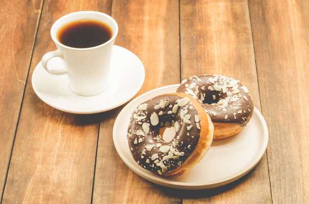 coffee break. White cup with black coffee and donat in chocolat - Fotografie, Obrázek