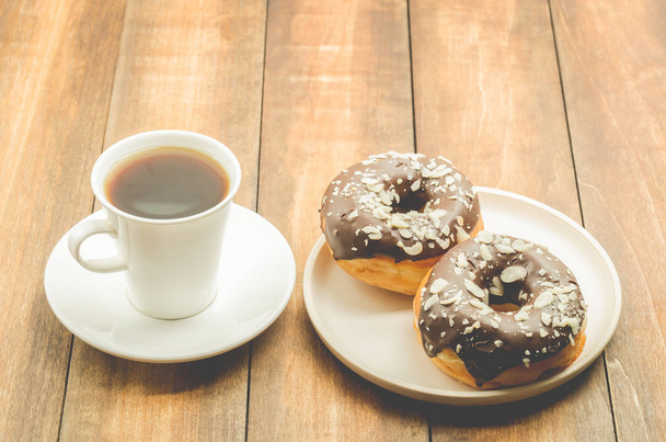 coffee break. White cup with black coffee and donat in chocolat - Fotografie, Obrázek