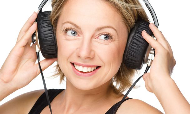 Young woman enjoying music using headphones - Foto, Bild