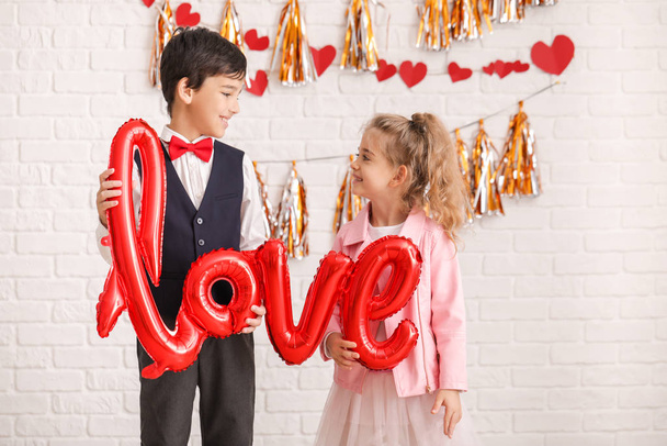 Cute little children with air balloon in shape of word LOVE indoors. Valentines Day celebration - Фото, зображення
