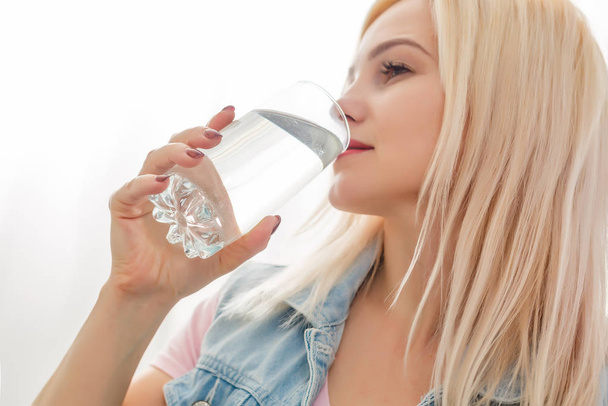 Mujer joven bebiendo pastillas y agua
 - Foto, imagen