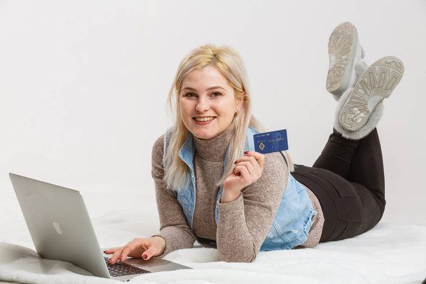 Μια ευτυχισμένη γυναίκα κρατώντας μια πιστωτική κάρτα και ψώνια από το διαδίκτυο - Φωτογραφία, εικόνα