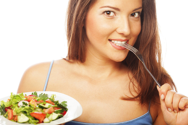 Young happy woman eating salad. - 写真・画像
