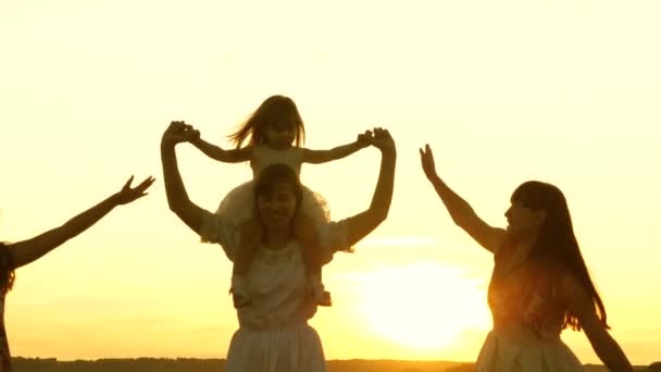 Mother and daughters walks in park and play in the meadow in sun. concept of life of a large family. happy childhood concept. Happy young family with a child run across field in flight at sunset light - Footage, Video