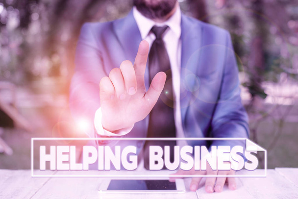 Writing note showing Helping Business. Business photo showcasing improving some measure of an enterprise s is success Businessman with pointing finger in front of him. - 写真・画像