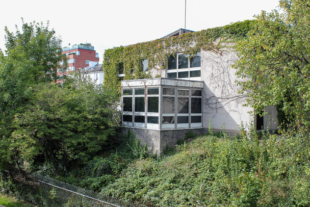 Παλιό εγκαταλελειμμένο κτίριο κατάφυτα φυτά, καλυμμένα με πράσινα φυτά - Φωτογραφία, εικόνα