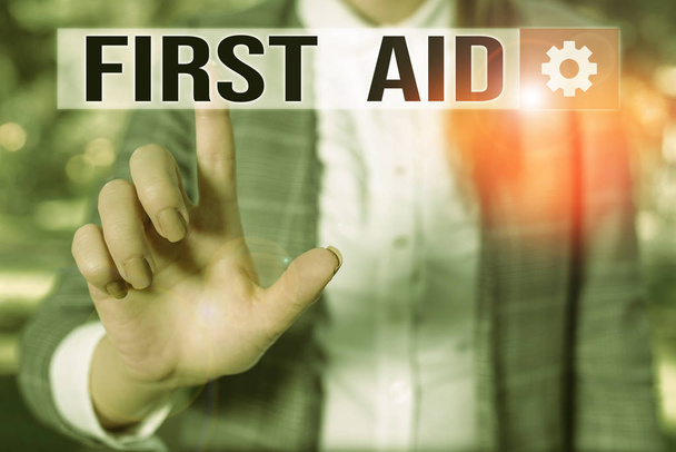 Text sign showing First Aid. Conceptual photo Practise of healing small cuts that no need for medical training Business woman in the nature pointing with the finger into empty space. - Photo, Image