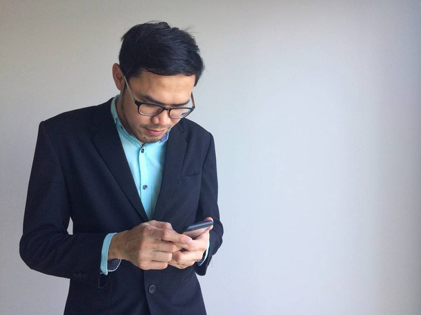 Бізнесмен використовує мобільний телефон за межами офісу. людина тримає смартфон для ділової роботи
. - Фото, зображення