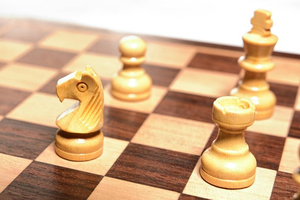 白い背景にチェス盤の上の角度ショット。木造チェス駒. - 写真・画像