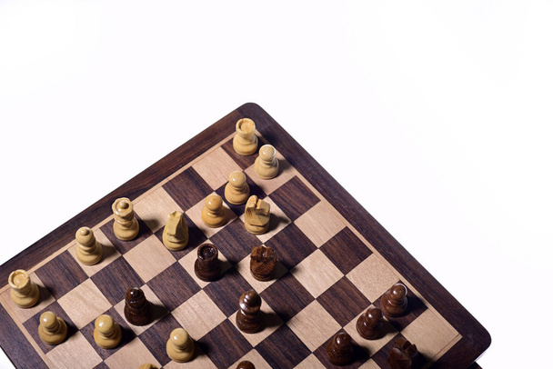 Satranç tahtasındaki satranç taşlarının üst açısıyla beyaz arka plan karşı karşıya. Tahta satranç taşları. - Fotoğraf, Görsel