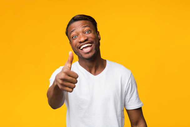 Positive Black Man Gesturing Thumbs Up Standing Over Yellow Background - Foto, Imagem