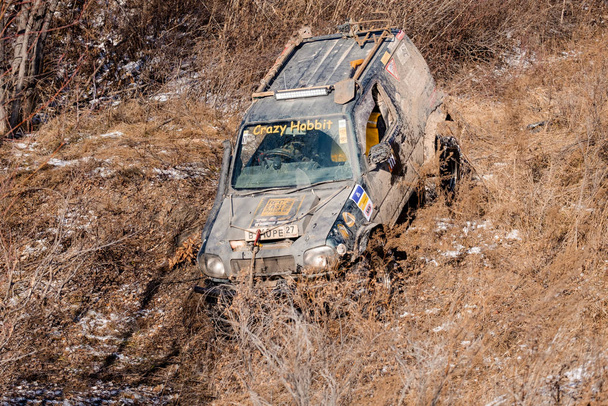 Khabarovsk, Oroszország - 2019. november 11.: Jeep Suzuki Jimny legyőzi az akadályokat az erdőben. - Fotó, kép