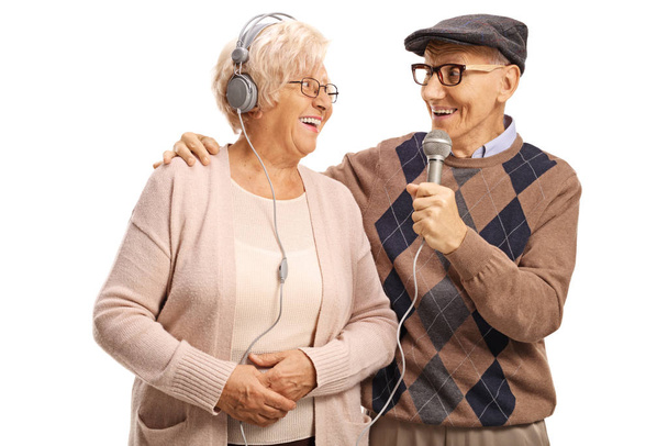 Elderly man singing on a microphone to an elderly woman with hea - Fotoğraf, Görsel