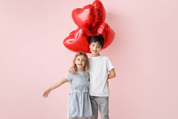 カラーを背景に気球を持つかわいい子供たち。バレンタインデーのお祝い - 写真・画像