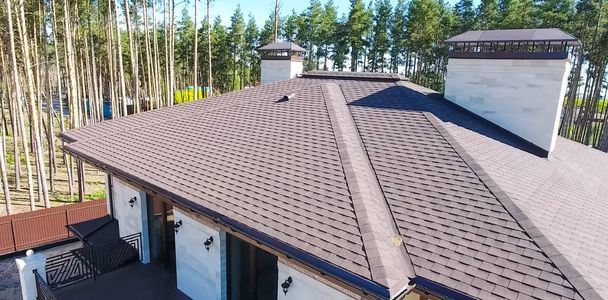 Tuile bitumineuse pour un toit. Maison avec un toit en tuile bitumineuse. un toit d'une tuile bitumineuse. Moder
 - Photo, image