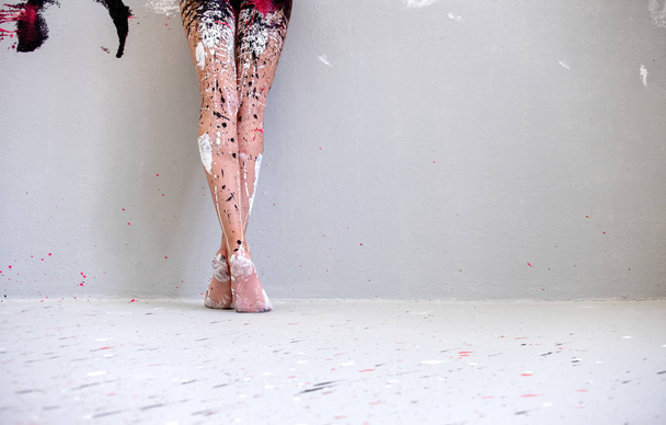 belle gambe e piedi di una giovane donna dipinta artisticamente astratta, ballerina con vernice bianca, nera e rossa. Pittura creativa di body art, spazio di copia
. - Foto, immagini