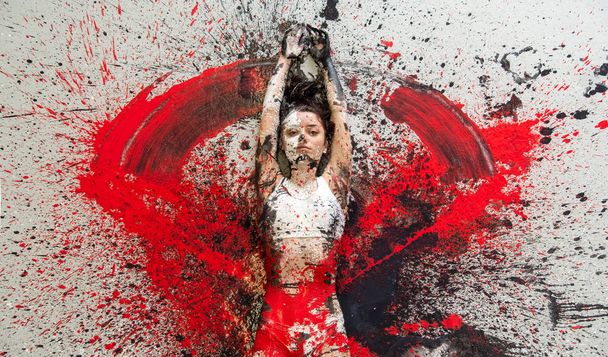 Jonge vrouw in ondergoed en sportbeha liggend op de vloer elegant decoratief, in rode, zwarte en witte kleur. Creatieve, expressieve body art en schilderkunst. - Foto, afbeelding