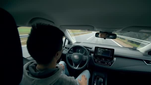 Automatic, self-driving car. A person sits in a driver seat while a car goes on autopilot. - Materiaali, video