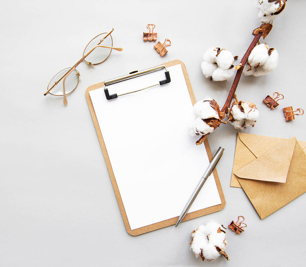Stylized arranged office accessories clipboard, clips, glasses, cotton flowers, pen. Women's fashion accessories  on white background. Flat lay Top view - Photo, Image