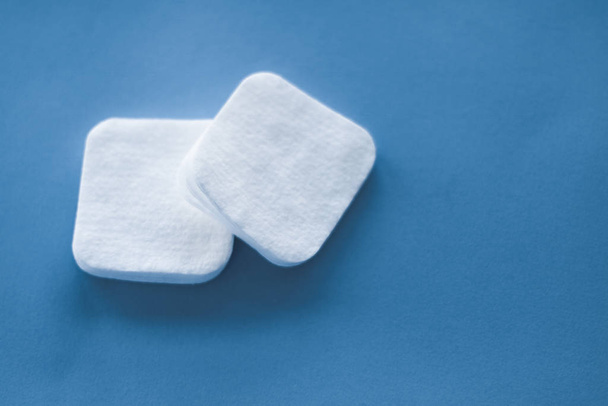 Tampons en coton biologique sur fond bleu, cosmétiques et maquillage
 - Photo, image