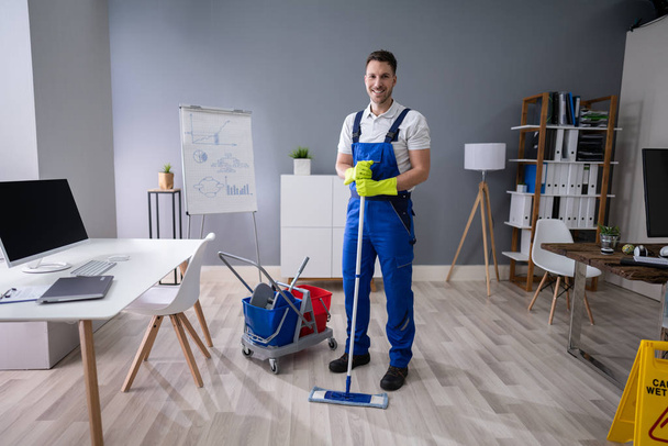 Full Length Portrait Of Happy Male Worker With Broom Cleaning Office - Foto, Bild