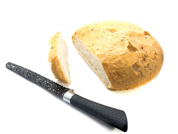 Mes en brood geïsoleerd op een witte achtergrond. Samenstelling van een zwart mes, pitabrood en een sneetje brood. Set van keramisch mes en rond brood. Snijd in plakjes pita en mes. - Foto, afbeelding