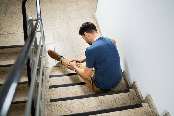 Man Sitting On Staircase After Slip And Fall Accident - Photo, Image