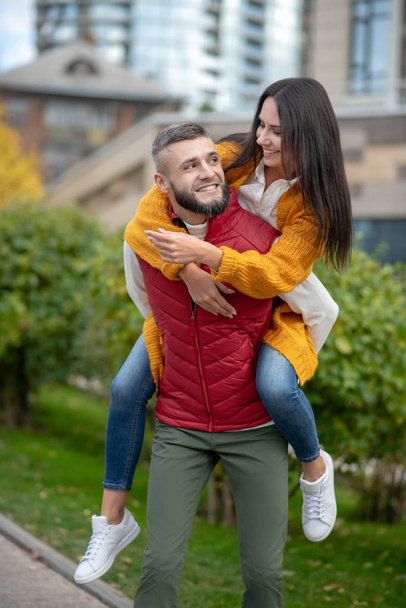 Happy young strong man holding his girlfriend - Fotó, kép