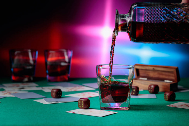 Casino table with cards and dice . Whisky is poured into a glass - 写真・画像