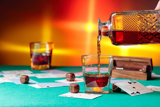 Casino table with cards and dice . Whisky is poured into a glass - Фото, зображення