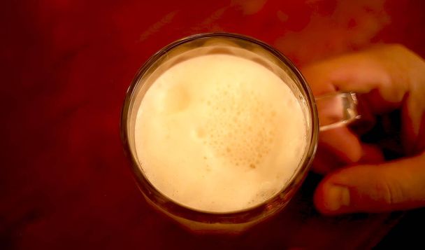 beer mug on a table in a male hand in a pub - 写真・画像