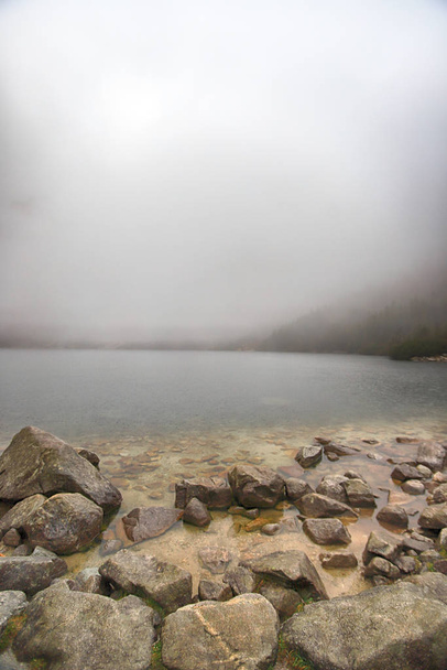 Tátra Nemzeti Park a lengyel Magas-Tátra. Lake Morskie Oko (Eye of the Sea Lake) egy ködös és esős napon, Zakopane, Lengyelország, Európa. - Fotó, kép