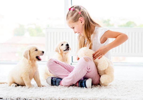 Puppies play with cheerful girl - Фото, зображення