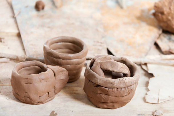 Handmade raw clay pots on the crafts table - Φωτογραφία, εικόνα